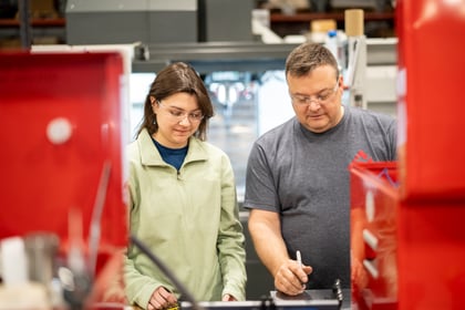 A man helping an intern during her STEM internship. 